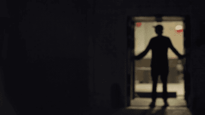 silhouette of a man closes the sliding door in a dark room rqelynpci thumbnail full01